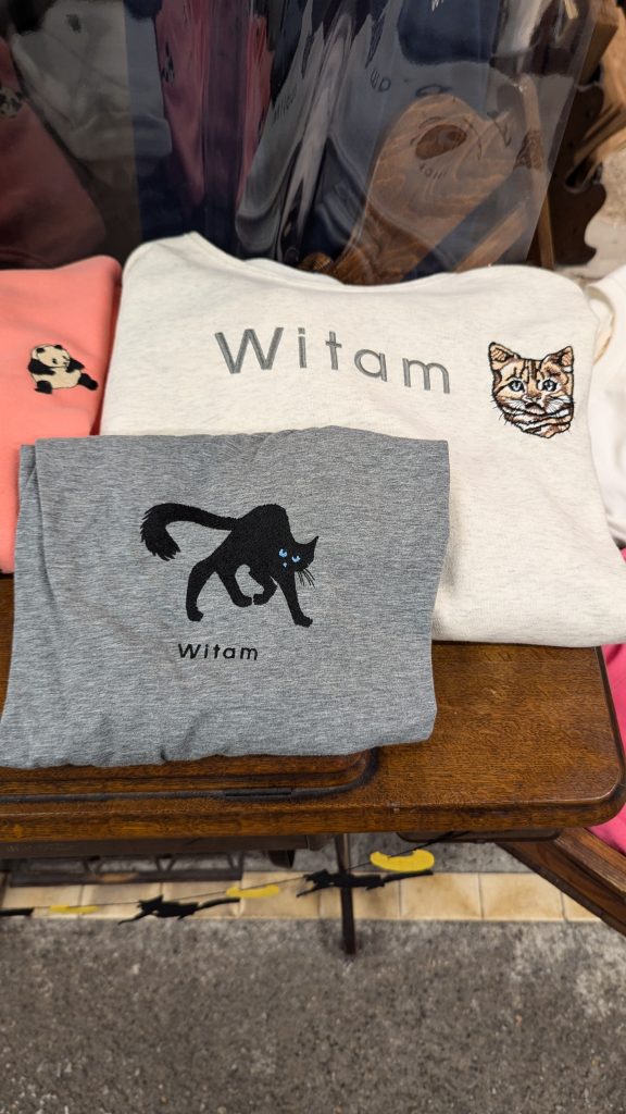 Koszulki z wyhaftowanym kotem i napisem "Witam".